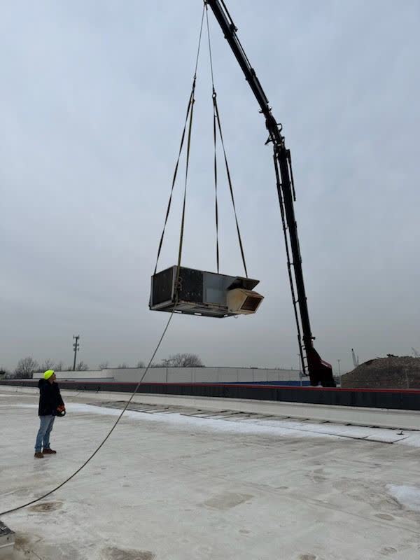 Crane setting a new AC unit