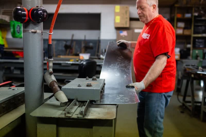 Community II crew member forming sheet metal on the brake in the Broad Street shop