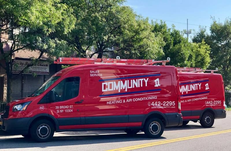 Two Community II vans parked on a tree-lined Staten Island street